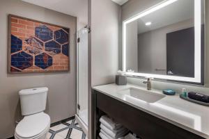 a bathroom with a sink and a toilet and a mirror at Vīb Hotel by Best Western Denver RiNo in Denver +16 photos