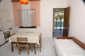a room with a table and chairs and a kitchen at Apartment Bilo 4189a in Podgreben