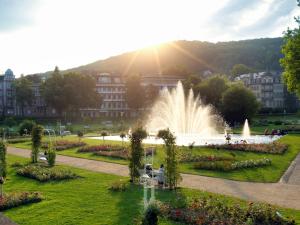 a fountain in a park in front of a building at BRISTOL Hotel Bad Kissingen in Bad Kissingen