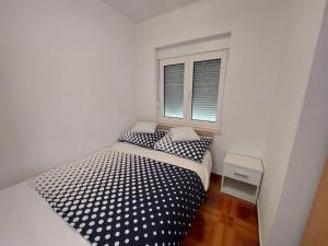 Schlafzimmer mit einem Bett mit schwarzen und weißen Polka-Punkten in der Unterkunft Apartments by the sea Rastici, Ciovo - 4293 in Trogir