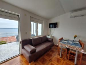 ein Wohnzimmer mit einem Sofa und einem Tisch in der Unterkunft Apartments by the sea Rastici, Ciovo - 4293 in Trogir