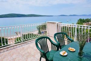 einen grünen Tisch und Stühle auf einem Balkon mit Blick auf das Wasser in der Unterkunft Apartments by the sea Zablace, Sibenik - 4222 in Zablaće