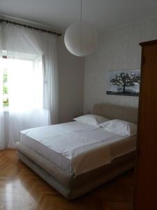 a bedroom with a white bed with a large window at Apartments and rooms by the sea Sumpetar, Omis - 2099 in Jesenice