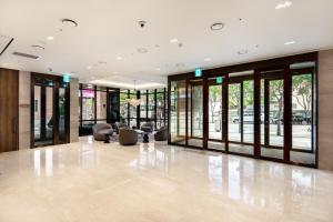 een lobby met glazen deuren en stoelen in een gebouw bij G3 Hotel Chungmuro in Seoul