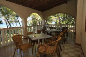 a row of tables and chairs on a porch at Double Room Pasman 4309a in Pašman