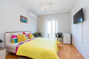 a bedroom with a yellow bed with colorful pillows at Rooms by the sea Pasman - 4309 in Pašman