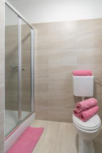 a bathroom with a toilet and a shower with pink towels at Rooms by the sea Pasman - 4309 in Pašman