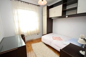 a bedroom with a bed and a desk and a window at Apartments by the sea Slatine, Ciovo - 1137 in Slatine