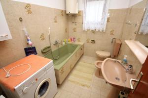 a bathroom with a tub and a toilet and a sink at Apartments by the sea Slatine, Ciovo - 1137 in Slatine