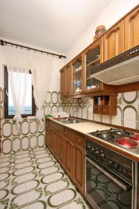 a kitchen with wooden cabinets and a stove at Apartments by the sea Slatine, Ciovo - 1137 in Slatine