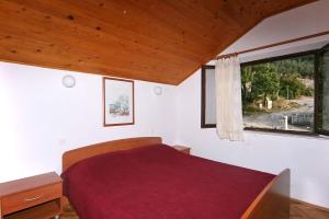 a bedroom with a red bed and a window at Rooms by the sea Sladjenovici, Dubrovnik - 2161 in Slano