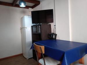 uma cozinha com uma mesa azul e um frigorífico em EL MONO DE LU em San Carlos de Bariloche