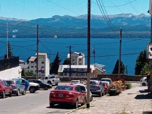 um grupo de carros estacionados numa rua com vista para a água em EL MONO DE LU em San Carlos de Bariloche