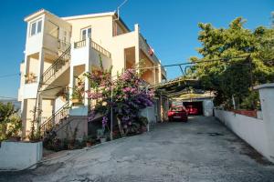 a house with a car parked in the driveway at Apartment Arbanija 1122b in Trogir