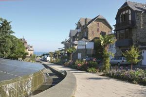una calle de la ciudad con casas y una acera con flores en Appt 3 pièces haut de gamme dans la " Villa Hortense" à 200 m plage, en Dinard