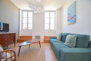 Sala de estar con sofá azul y mesa de centro en Appt 3 pièces haut de gamme dans la " Villa Hortense" à 200 m plage, en Dinard