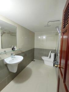 uma casa de banho com um lavatório, um WC e um espelho. em SixPearl Hotel em Con Dao