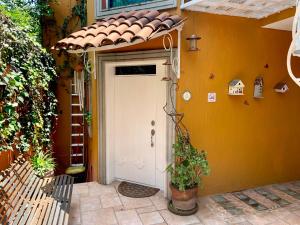 una casa naranja con una puerta blanca con techo en Satya Suites & Portal San Angel Flats, en Ciudad de México