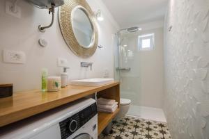 een badkamer met een wastafel, een toilet en een spiegel bij Apartments by the sea Pisak, Omis - 1067 in Pisak