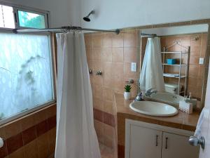 a bathroom with a shower curtain and a sink at Satya Suites & Portal San Angel Flats in Mexico City
