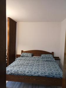 a bed with a blue comforter in a room at Anna's in Sibiu