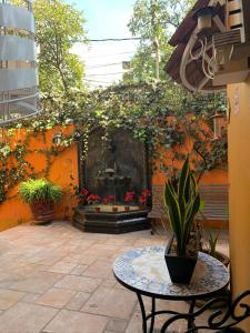 a patio with a fireplace and a table with a plant at Satya Suites & Portal San Angel Flats in Mexico City