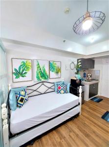 a bedroom with a white bed with pillows on it at Ohana at Tagaytay Prime in Tagaytay