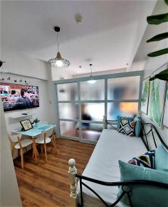 Ohana at Tagaytay Prime في تاجيتاي: غرفة نوم مع سرير وغرفة طعام مع طاولة