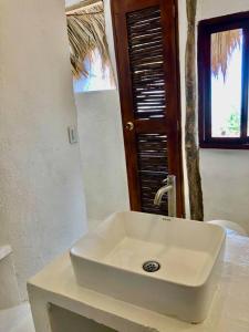 um lavatório branco numa casa de banho com uma janela em Acuarela del Mar em Dibulla