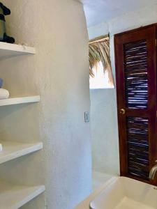 uma casa de banho com um lavatório e uma porta de madeira em Acuarela del Mar em Dibulla
