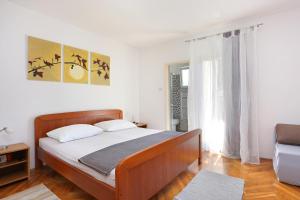 sypialnia z dużym łóżkiem i oknem w obiekcie Apartments and rooms by the sea Arbanija, Ciovo - 1125 w Trogirze