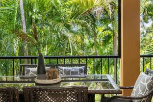 een tafel en stoelen op een balkon met palmbomen bij Corona St Secluded Sunshine Beach Duplex with Private Pool in Sunshine Beach