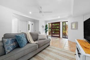 ein Wohnzimmer mit einem Sofa und einem TV in der Unterkunft Corona St Secluded Sunshine Beach Duplex with Private Pool in Sunshine Beach