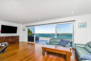 a living room with a couch and a tv at Omaroo Prestige Waterfront in Iluka