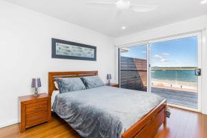 a bedroom with a bed and a large window at Omaroo Prestige Waterfront in Iluka
