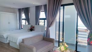a bedroom with a bed and a chair and windows at 5A - Pool seaview Blue Sea Apartment in Da Nang +3 photos