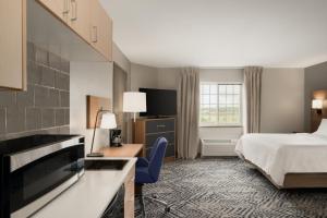 ein Hotelzimmer mit einem Bett und einem Schreibtisch in der Unterkunft Candlewood Suites Watertown Fort Drum, an IHG Hotel in Evans Mills
