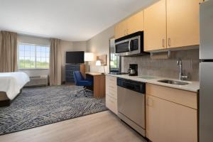 a hotel room with a kitchen and a bed at Candlewood Suites Watertown Fort Drum, an IHG Hotel in Evans Mills