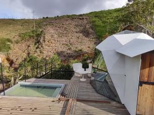 una casa de cristal con una piscina profunda en una terraza de madera en Glamping Paraiso, en San Roque