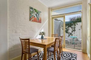 a dining room with a wooden table and chairs at Cosy Glebe cottage - walk to central Hobart in Hobart