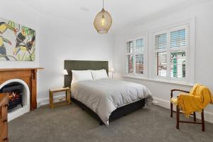 a bedroom with a bed and a fireplace at Fabulous 2 level city pad in historic building in Hobart