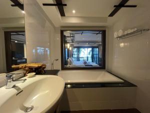 a bathroom with a sink and a tub and a mirror at Panviman Resort Koh Phangan - SHA Extra Plus in Thong Nai Pan Noi