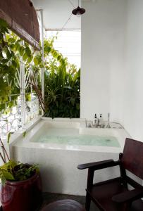 a bath tub in a room with plants at The Myst Dong Khoi in Ho Chi Minh City