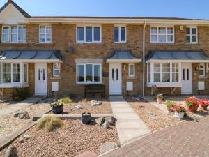 a brick house with white doors and a courtyard at Tidal Drift in Weymouth