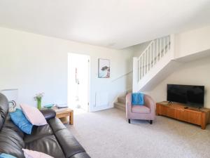 uma sala de estar com um sofá de couro e uma televisão em Tidal Drift em Weymouth