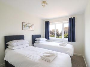 2 Betten in einem Zimmer mit Fenster in der Unterkunft Tidal Drift in Weymouth