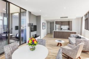 sala de estar con mesa y sillas en Meriton Suites Church Street, Parramatta en Sídney