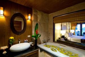 a bathroom with a tub and a sink and a bedroom at Panviman Resort Koh Phangan - SHA Extra Plus in Thong Nai Pan Noi