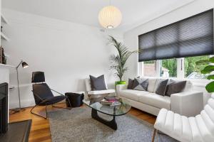 ein Wohnzimmer mit einem weißen Sofa und einem Glastisch in der Unterkunft Pillinger Street - luxurious renovated home in Hobart