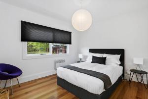 a bedroom with a large bed and a window at Pillinger Street - luxurious renovated home in Hobart